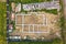 Aerial view of building site for future brick house, concrete foundation floor and stacks of yellow clay bricks for construction