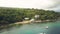 Aerial view buildings on tropical island on sea beach. Resort hotel on sea shore with turquoise water view from above