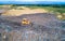 Aerial view on bulldozer working on the landfill.