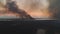 Aerial view of burning fire in tropical jungle in exotic caribbean resort. Rescue fire helicopter collects water into the sea and