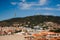 Aerial view of a bustling city, surrounded by a hilly landscape in the background: Barcelona