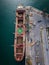 aerial view of a bustling seaport, where a massive cargo ship, a bulk carrier, is being loaded with wheat grains