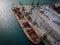 aerial view of a bustling seaport, where a massive cargo ship, a bulk carrier, is being loaded with wheat grains