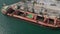 aerial view of a bustling seaport, where a massive cargo ship, a bulk carrier, is being loaded with wheat grains