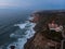 Aerial view of Cabo da Roca lighthouse steep rocky cliffs beach rough coast atlantic ocean Sintra-Cascais Natural Park