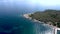 Aerial view of cape with trees and speedboats in stunning blue sea, Pefkohori Halkidiki, Greece, moving forward by drone