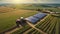 Aerial view captures the expansive farmland, adorned with a tractor navigating through the rows of crops, while solar cells gleam