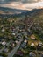 Aerial view capturing the serene beauty of a rural town as the sunset paints the landscape in soft, warm hues, with