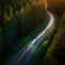 Aerial view of a car driving down a winding road in the forest