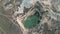 Aerial view of car by the edge of a flooded quarry.