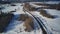 Aerial view of car moving on road in winter season. Bird's eye view of automobile driving in countryside.