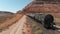 Aerial view of the cargo locomotive railroad engine crossing Arizona desert wilderness.