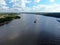 Aerial view cargo merchant ship sails along the river. Transport of goods by river barges. Beautiful landscape of the river.