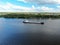 Aerial view cargo merchant ship sails along the river. Transport of goods by river barges. Beautiful landscape of the river.