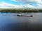 Aerial view cargo merchant ship sails along the river. Transport of goods by river barges. Beautiful landscape of the river.