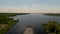 Aerial view the cargo ship floats down the river surrounded by forest