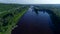 Aerial view the cargo ship floats down the river surrounded by forest