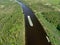 Aerial view the cargo ship floats down the river surrounded by forest. Beautiful panoramic landscape from the height