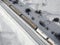 Aerial view of cargo train tank wagons, a double-track railway. Winter rail road with white snow, top view