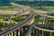 Aerial view of cars driving on complex highway or freeway with trees. Bridge roads or streets in structure of architecture and