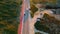 Aerial view cars riding on rural road summer day. Roadway on stony terrain.