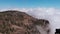 Aerial view - cell tower in the mountains, above the clouds, around the pine forest