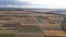 Aerial view of cereal fields after the harvest with haystack and tractor tread