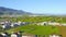 Aerial view of charming town and field in sunlight, train going through town