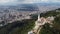 Aerial view of a church on top of a green hill against the cityscape of Bogota, Venezuela