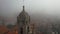 Aerial view of church tower and birds in the fog, Portugal