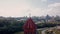 Aerial view of a church tower top of red tiles with a golden cross. Video. Details of a red brick building with a city