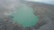 Aerial view cinematic volcano acid turquoise lake in crater smoke fume famous touristic place