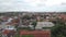 Aerial view of city from behind the trees. Many rooftops of buildings