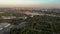 Aerial view on city with cars and buildings on street and river with shipyards with cranes on it