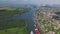 Aerial view: city by the river, barges and boats, green meadows and forests