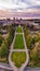 Aerial view of a cityscape featuring a lush green park and a cloudy sky in the background