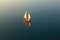 aerial view of classic sailboat gliding on calm sea