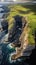 Aerial view of cliffs, waves, cloudy sky and green grass in Faroe Islands