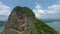 Aerial view climbing to mountain top rock texture tropical greenery picturesque sea ocean landscape