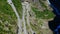 Aerial view of coach bus cautiously making a sharp turn on Trollstigen or Trolls Path, a popular narrow serpentine mountain road.