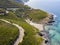 Aerial view of the coast of Corsica, winding roads and coves with crystalline sea. France