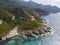 Aerial view of the coast of Corsica, winding roads and coves with crystalline sea. France