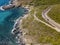 Aerial view of the coast of Corsica, winding roads and coves. Motorcyclists parked on the edge of a road. France