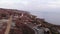 Aerial view of the coast of the sea and the lighthouse with buildings on the hill