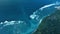Aerial view of coastline with ocean waves and powerful current canal in Bali
