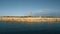 Aerial view of the coastline with rocks from the sea and on the land old lighthouse and wind turbine power generators