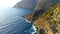 Aerial view of coastline rocky cliff with green trees in Mediterranean sea