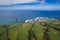 Aerial view of the coastline on Sao Miguel Island, with town buildings, green farmland and volcanic mountains, Azores, Portugal