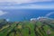 Aerial view of the coastline on Sao Miguel Island, with town buildings, green farmland and volcanic mountains, Azores, Portugal