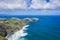 Aerial view of the coastline on Sao Miguel Island, with town buildings, green farmland and volcanic mountains, Azores, Portugal